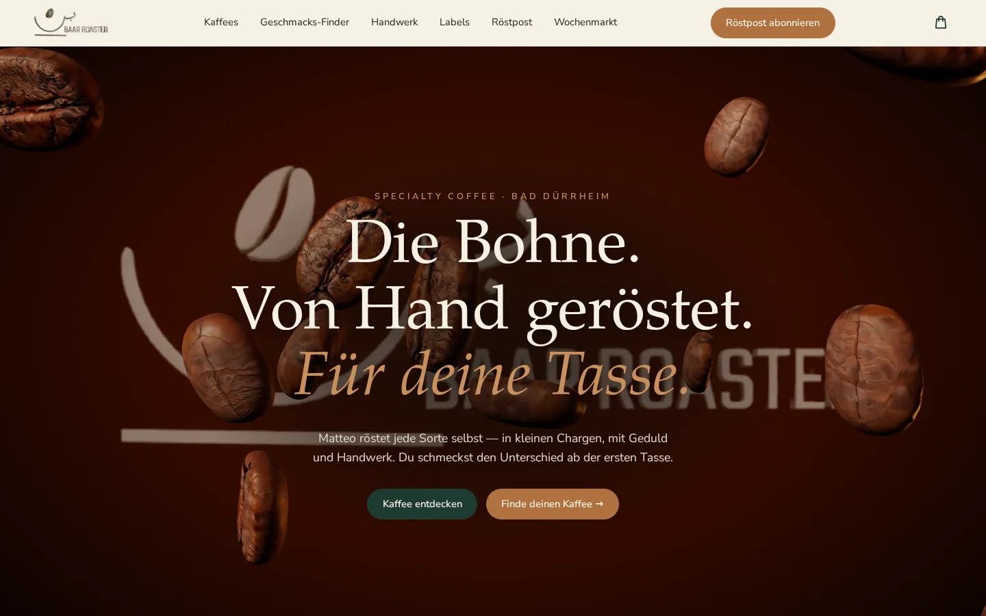 Startbildschirm des Website-Prototyps am Desktop: dunkelbrauner Hintergrund mit schwebenden 3D-Kaffeebohnen, die Überschrift „Die Bohne. Von Hand geröstet. Für deine Tasse.“, darunter zwei Knöpfe, oben die Navigation mit Logo und Warenkorb.